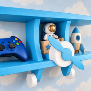 Close-up of blue wooden aeroplane wall shelf styled with children’s toys