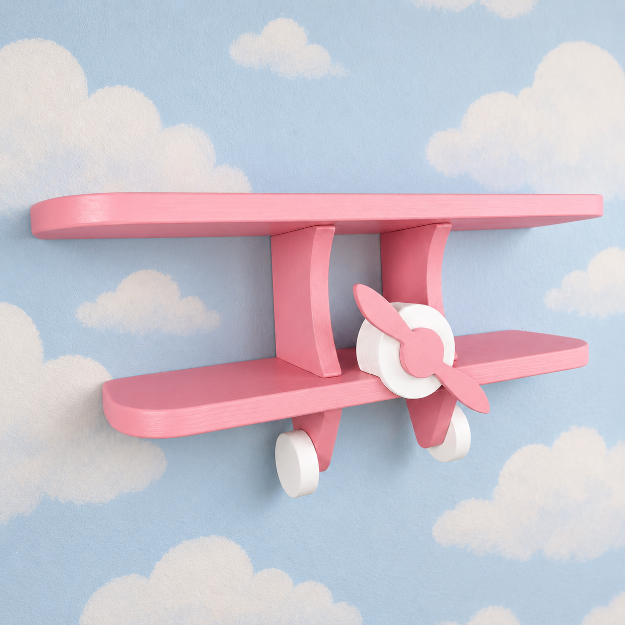Pink wooden aeroplane wall shelf for kids shown at an angle