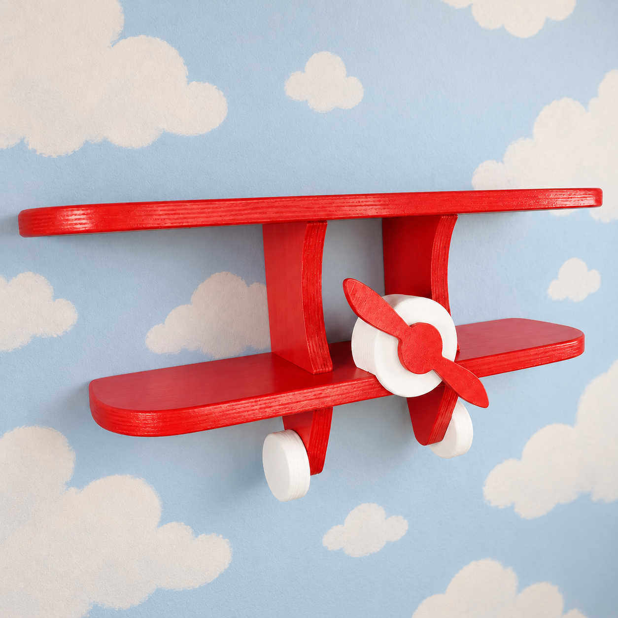 Red wooden aeroplane wall shelf for kids shown at an angle
